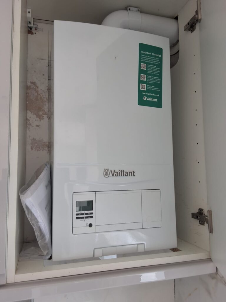 Vaillant condensing combi boiler installed in a kitchen cupboard, seen during a London EPC assessment